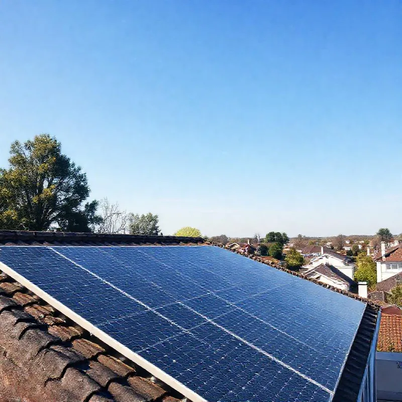 Toit avec panneaux solaires et quartier paisible en arrière-plan.